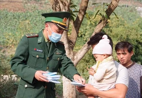 Cán bộ chiến sỹ đồn biên phòng cửa khẩu Ma Lù Thàng phát miễn phí khẩu trang y tế cho nhân dân bản Hùng Bèng, xã Ma Ly Pho (Phong Thổ, Lai Châu). Ảnh: Quý Trung – TTXVN