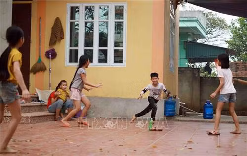Trẻ em chơi đùa tại sân nhà anh Dũng thôn Ái Văn. Ảnh: Hoàng Hùng -TTXVN