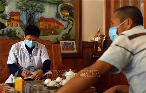 Anh Tạ Văn Thành Trung tâm kiểm soát bệnh tật tỉnh Vĩnh Phúc thu thập số liệu về người về từ khu cách ly COVID-19 tại thôn Ái Văn. Ảnh: Hoàng Hùng - TTXVN