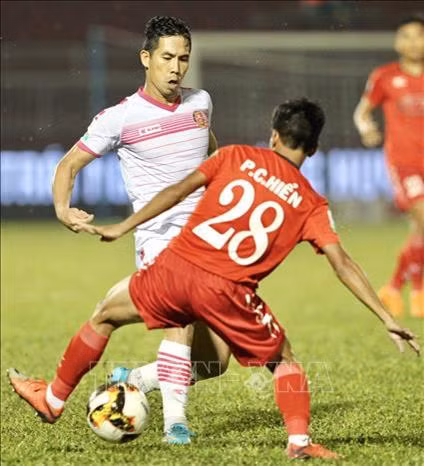 Hậu vệ Hoàng Quảng (6,SGFC) đi bóng trước sự truy cản của Công Hiển (28, Thành phố Hồ Chí Minh). Ảnh: Quang Nhựt – TTXVN