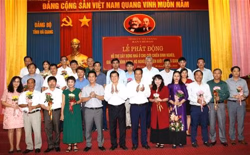 Nguyên Chủ tịch nước Trương Tấn Sang và lãnh đạo tỉnh Hà Giang tặng hoa, biểu dương các doanh nghiệp tham gia ủng hộ chương trình xây dựng nhà ở cho cựu chiến binh nghèo, gia đinh chính sách, hộ nghèo xã biên giới. Ảnh: Minh Tâm - TTXVN