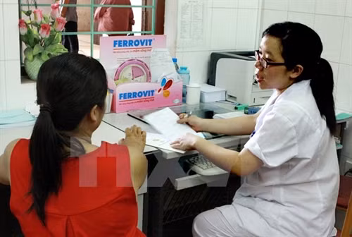 Nhân viên y tế tư vấn về sức khỏe cho thai phụ. (Ảnh: TTXVN)