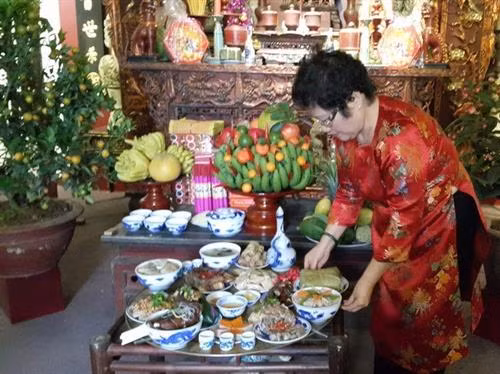 Nghệ nhân Ánh Tuyết với mâm cỗ Tết truyền thống Hà Nội. Ảnh: Đinh Thị Thuận - TTXVN