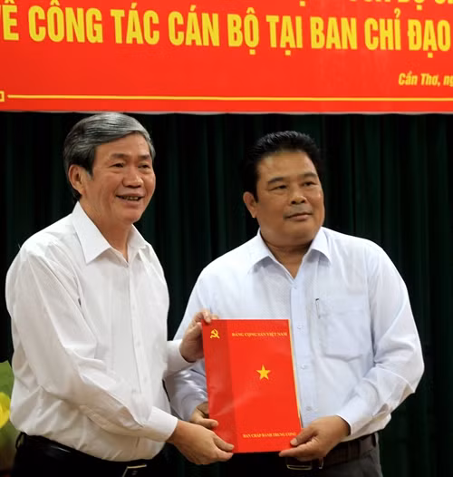 Thường trực Ban Bí thư Đinh Thế Huynh (trái) trao quyết định của Bộ Chính trị cho ông Sơn Minh Thắng (phải). Ảnh: Ngọc Thiện-TTXVN