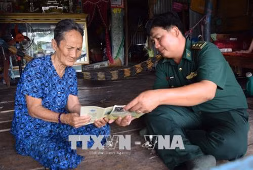 Bộ đội biên phòng Đồng Tháp tổ chức phát tờ rơi tuyên truyền về biển, đảo quê hương đến tận tay người dân vùng biên. Ảnh: Chương Đài - TTXVN