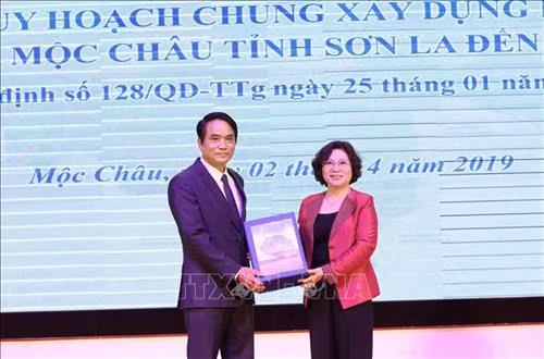 Thứ trưởng Bộ Xây dựng Phan Thị Mỹ Linh trao giao hồ sơ đồ án Quy hoạch chung xây dựng Khu du lịch quốc gia Mộc Châu cho Phó Chủ tịch UBND tỉnh Sơn La Lê Hồng Minh. Ảnh: Nguyễn Cường - TTXVN
