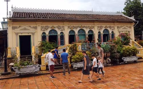 Du khách quốc tế tham quan nhà cổ.