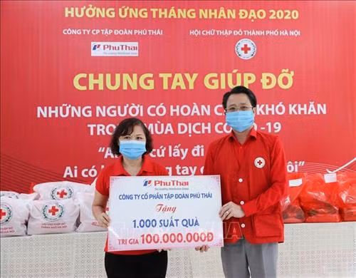 Đại diện Công ty Cổ phần Tập đoàn Phú Thái trao tượng trưng 1.000 suất quà cho người có hoàn cảnh khó khăn thông qua Hội Chữ thập đỏ thành phố Hà Nội. Ảnh: Thanh Tùng - TTXVN
