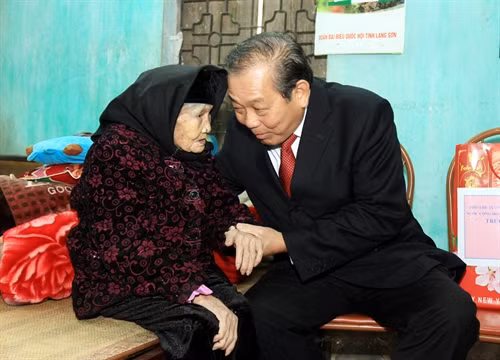 Phó Thủ tướng Trương Hòa Bình hỏi thăm sức khỏe mẹ Việt Nam anh hùng Trương Thị Ngưới, xã Quảng Lạc, thành phố Lạng Sơn. Ảnh: Thái Thuần – TTXVN