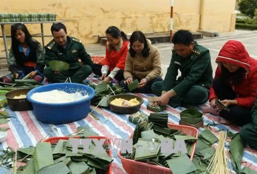 Cán bộ chiến sỹ đồn Biên phòng Mường Pồn cùng người dân gói bánh chưng chuẩn bị đón tết Mậu Tuất 2018. Ảnh: Phan Tuấn Anh – TTXVN