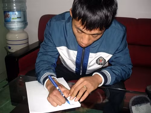 Bênh nhân nam này đã cầm được bút viết sau khi được cấy ghép ngón chân thành ngón tay. Ảnh: TTXVN phát