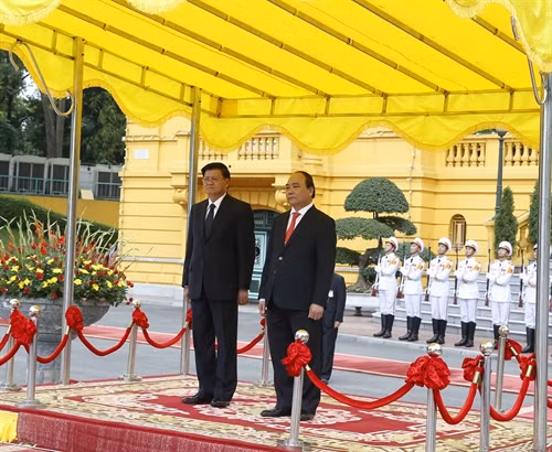 Nhận lời mời của Thủ tướng Chính phủ Nguyễn Xuân Phúc, Thủ tướng Chính phủ nước Cộng hòa Dân chủ Nhân dân Lào Thongloun Sisoulith và Phu nhân cùng Đoàn đại biểu cấp cao Chính phủ nước CHDCND Lào thăm hữu nghị chính thức Việt Nam từ ngày 15 – 17/5/2016. Trong ảnh: Thủ tướng Chính phủ Nguyễn Xuân Phúc và Thủ tướng Chính phủ nước Cộng hòa Dân chủ Nhân dân Lào Thongloun Sisoulith tại lễ đón. Ảnh: Thống Nhất-TTXVN