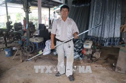 Ông Lê Phước Lộc với chiếc kéo cắt tỉa đa năng. Ảnh: Minh Trí - TTXVN