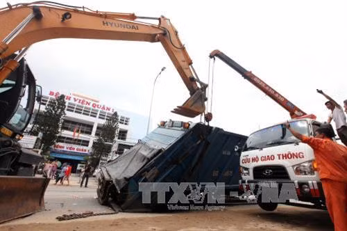 Lực lượng cứu hộ đưa chiếc xe chở rác ra khỏi “hố tử thần”. Ảnh: Mạnh Linh-TTXVN