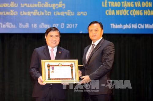 Đồng chí Xẳn-tị-phạp Phôm-vi-hản, UV BCH Trung ương Đảng Nhân dân Cách mạng Lào, Bí thư – Tỉnh trưởng Savanakhet, trao tặng Huân chương Lao động hạnh I của nước CHDCND Lào cho Đảng bộ, chính quyền và nhân dân Thành phố. Ảnh: Thanh Vũ-TTXVN