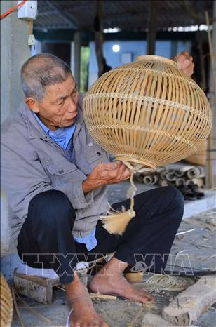 Các nghệ nhân làng nghề Bao La đang đan các sản phẩm mây, tre. Ảnh: Hồ Cầu-TTXVN