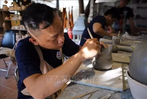 Các em khuyết tật học nghề làm gốm. Ảnh: Hồ Cầu-TTXVN