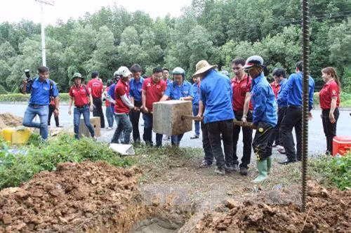 Đoàn thanh niên CNLĐ Thành phố phối hợp cùng Huyện đoàn Cần Giờ thực hiện cắm bảng đường dây nóng về giao thông, cấp cứu, vá xe lưu động trên tuyến đường Cần Giờ. Ảnh: Thanh Vũ – TTXVN