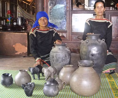 Nghệ nhân Yo Khoanh (phải) bên những sản phẩm bằng gốm