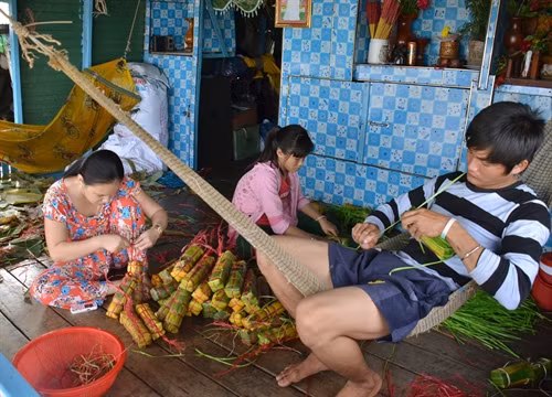 Các hộ gia đình Việt kiều ở Biển Hồ Tonle Sap gói bánh tét chuẩn bị cho ngày Tết. Ảnh: Phan Minh Hưng-Phóng viên TTXVN tại Campuchia