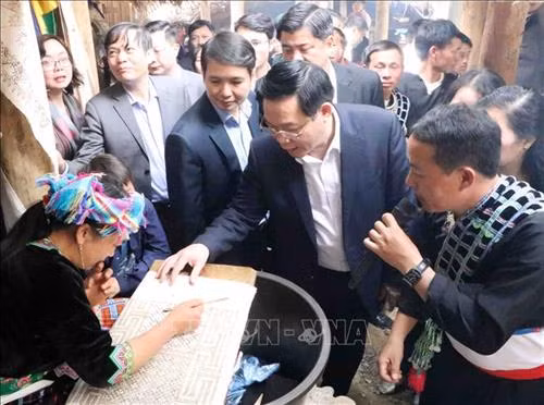 Phó Thủ tướng Vương Đình Huệ thăn bà con dân tộc Mông đang phục dựng kỹ thuật vẽ trên vải bằng sáp ong tại bản Sin Suối Hồ. Ảnh: Công Tuyên-TTXVN