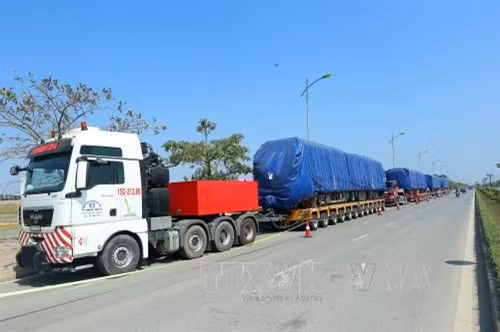 Các thiết bị, toa tàu được phủ kín bạt, vận chuyển bằng xe đầu kéo siêu trương, siêu trọng. Ảnh: Huy Hùng- TTXVN