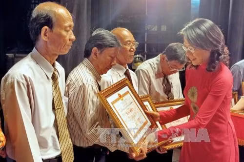 Phó Chủ tịch UBND Thành phố Hồ Chí Minh Nguyễn Thị Thu trao Bằng khen của UBND thành phố cho đại diện các tập thể có thành tích xuất sắc trong thực hiện phong trào “Toàn dân đoàn kết xây dựng đời sống văn hoá” liên tục nhiều năm liền, tại hội nghị. Ảnh: Thế Anh-TTXVN
