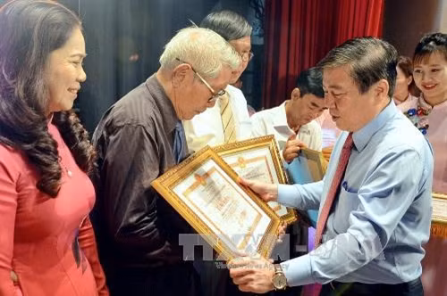 Chủ tịch UBND Thành phố Hồ Chí Minh Nguyễn Thành Phong trao tặng Bằng khen cho các hộ gia đình có thành tích xuất sắc trong thực hiện phong trào “Toàn dân đoàn kết xây dựng đời sống văn hoá” liên tục nhiều năm liền. Ảnh: Thế Anh-TTXVN