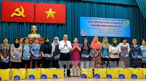 Phó Thủ tướng thường trực Trương Hòa Bình cùng các nhà tài trợ và thành viên ban tổ chức chương trình trao các suất quà tết cho đồng bào người Chăm trên địa thành phố. Ảnh : Thế Anh-TTXVN