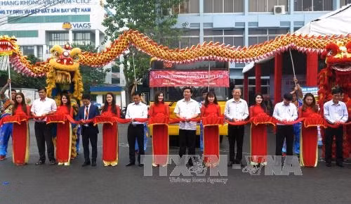 Bí thư Thành ủy Đinh La Thăng cùng lãnh đạo Thành phố cắt băng khai trương tuyến xe buýt mới số 159 - xe buýt chất lượng cao đưa vào hoạt động từ sân bay Tân Sơn Nhất đi Bến xe An Sương và Bến xe Miền Đông. Ảnh : Hoàng Hải-TTXVN