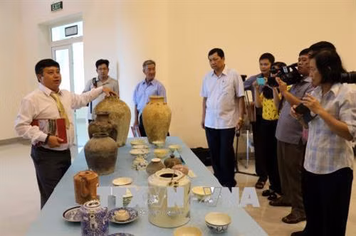Nhà sưu tập Nguyễn Ngọc Ẩn giới thiệu về cổ vật hiến tặng. Ảnh: Đoàn Mạnh Dương-TTXVN