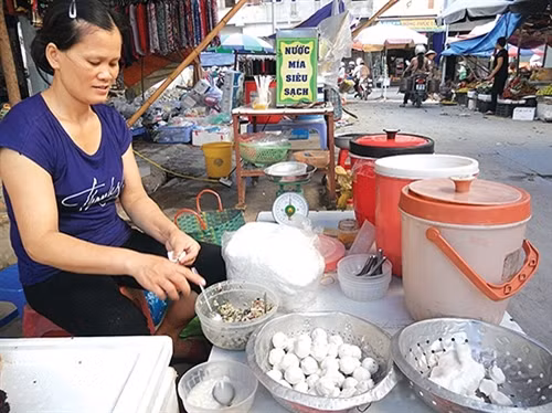Từng lớp bánh hòn đem xếp dần vào chõ đang nghi ngút hơi nước nóng.