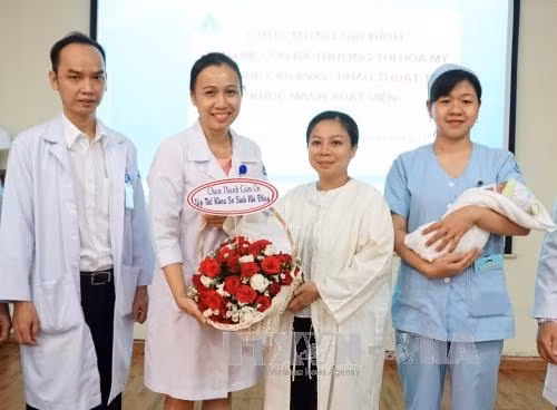 Sau một tháng phẫu thuật, bé gái đã khỏe mạnh và xuất viện về nhà trong niềm vui mừng của các bác sĩ và gia đình. Ảnh: Phương Vy-TTXVN.