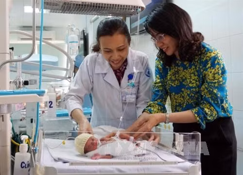 Lãnh đạo UBND Thành phố Hồ Chí Minh thăm cháu bé sau cuộc phẫu thuật thành công. Ảnh: Phương Vy - TTXVN.