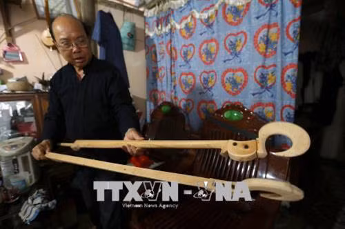 Nghệ nhân Mào Văn Ết kiểm tra những cần đàn mới được làm. Ảnh: Phan Tuấn Anh - TTXVN