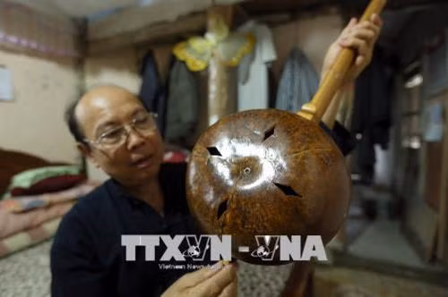 Nghệ nhân Mào Văn Ết nói về cách thức chế tác một cây đàn tính tẩu. Ảnh: Phan Tuấn Anh - TTXVN