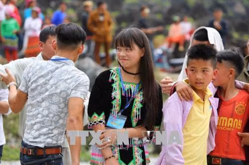 Các chàng trai tán tỉnh cô gái dân tộc Mông tại chợ tình Khâu Vai. Ảnh: Thành Đạt - TTXVN
