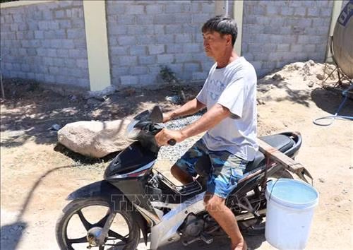 Người dân thôn Bình Tiên, xã Công Hải, huyện Thuận Bắc (Ninh Thuận) chở nước từ điểm cấp nước do lực lượng vũ trang tỉnh hỗ trợ về sinh hoạt. Ảnh: Công Thử - TTXVN