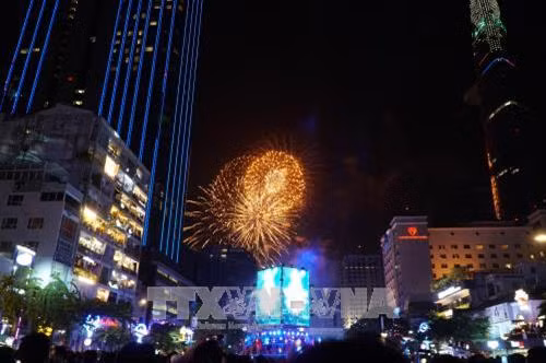 Người dân xem bắn pháo hoa trong thời khắc chuyển giao giữa năm cũ và năm mới 2018 tại đường Nguyễn Huệ, Thành phố Hồ Chí Minh. Ảnh: Phương Vy -TTXVN.