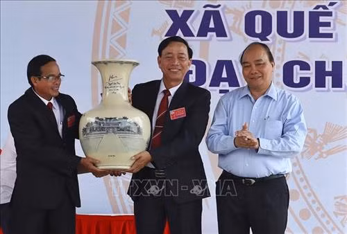Thủ tướng Nguyễn Xuân Phúc tặng quà lưu niệm, chúc mừng Đảng bộ, chính quyền và nhân dân xã Quế Phú. Ảnh: Thống Nhất – TTXVN