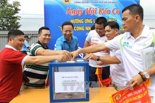 Công nhân lao động tham gia Ngày hội kéo co và ủng hộ “Chương trình vì người bạn đoàn viên Công đoàn”. Ảnh: Thanh Vũ - TTXVN.