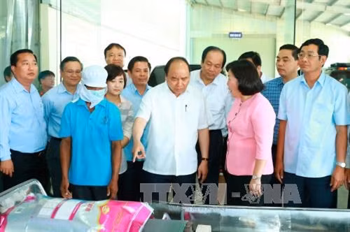 Thủ tướng Nguyễn Xuân Phúc đến thăm Nhà máy chế biến lương thực Thành Tín, thành phố Sóc Trăng. Ảnh: Thống Nhất - TTXVN.