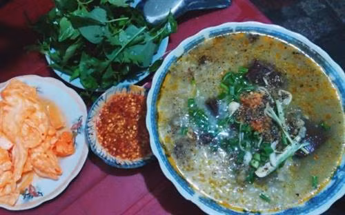 Cháo bò Quy Nhơn: Cháo bò - gỏi bò cũng là một "combo" hút khách tại thành phố Quy Nhơn, Bình Định. Về cơ bản, cháo bò đơn giản là cháo ăn với thịt bò nhưng hương vị của nó lại đẩy món ăn nghe chừng đơn giản lên một tầm cao mới. Nước cháo đậm đà, được hầm với xương bò, gia giảm với nhiều loại gia vị như hành, ngò gai tạo nên sự thơm ngon, hơi cay cay cho món cháo. Tô cháo bò lúc nào cũng đầy ắp thịt, từ gân bò, xương bò cho tới các loại lòng bò. Ảnh: Foody.