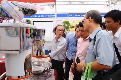 Ông Nguyễn Duy Linh ở phường 11, quận 3, TP.Hồ Chí Minh giới thiệu máy rửa cốc, chén bán tự động của với khách tham quan. Ảnh: Quang Quyết-TTXVN