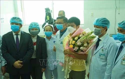 Bệnh nhân Li Zichao (áo vàng, 28 tuổi, quốc tịch Trung Quốc) xuất viện ngày 4/2. Ảnh: Đinh Hằng - TTXVN