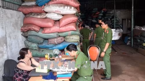 Lực lượng chức năng làm việc với chủ cơ sở sản xuất cà phê bẩn. Ảnh: TTXVN phát