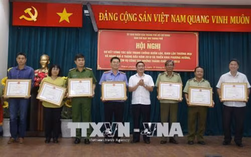 Trao Bằng khen của Ban chỉ đạo 389 quốc gia cho các tập thể có thành tích xuất sắc. Ảnh: Hoàng Hải - TTXVN