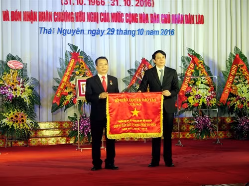 Ông Phsmj Mạnh Hùng (bên phải)- Thứ trưởng Bộ Giáo dục và Đào tạo trao cờ thi đua xuất sắc cho tập thể Trường Đại học Sư phạm- Đại học Thái Nguyên