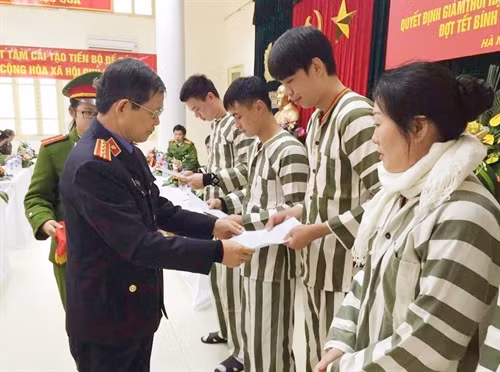 Đại diện Viện kiểm sát nhân dân thành phố Hà Nội trao quyết định giảm thời hạn chấp hành án phạt tù cho các phạm nhân. Ảnh: TTXVN