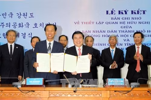Chủ tịch UBND Thành phố Hồ Chí Minh Nguyễn Thành Phong và Tỉnh trưởng tỉnh Gangwon Choi Moonsoon thực hiện nghi thức ký kết Biên bản ghi nhớ về Thiết lập quan hệ hữu nghị, hợp tác giữa UBND Thành phố Hồ Chí Minh và Chính quyền tỉnh Gangwon (Hàn Quốc). Ảnh: Thanh Vũ – TTXVN.